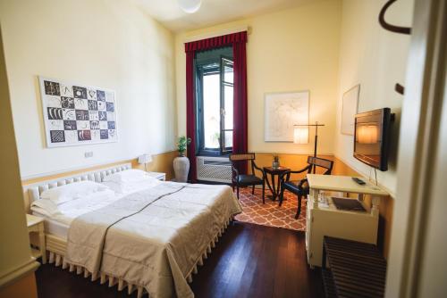 a bedroom with a bed and a table and a window at Boutique Hotel Dobra Vila Bovec in Bovec