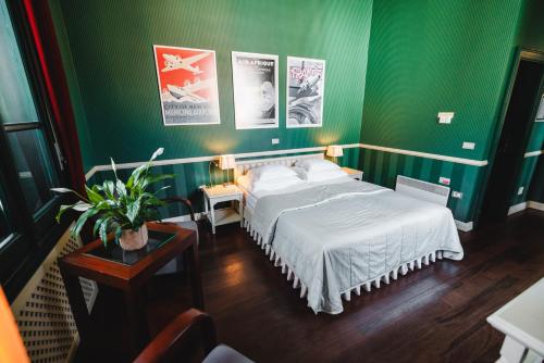 a bedroom with a green wall with a bed and a table at Boutique Hotel Dobra Vila Bovec in Bovec