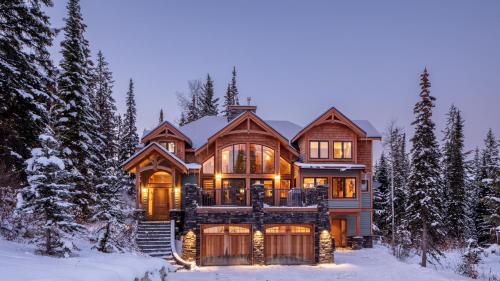 uma casa grande na neve com luzes acesas em Lush Mountain Accommodations em Golden