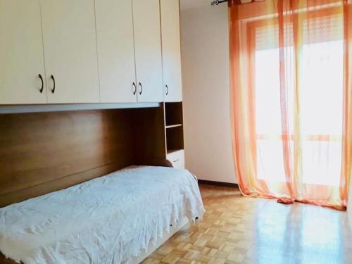 a bedroom with a bed and a large window at Appartamento bella vista dal castello al mare in Gradara