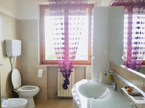 a bathroom with a tub and a sink and a window at Appartamento bella vista dal castello al mare in Gradara