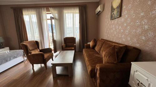 a living room with a couch and a table and a bed at Hotel RichI G A in Tbilisi City