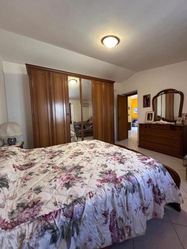 a bedroom with a large bed with a floral bedspread at Maria s Apartment in Tertenìa