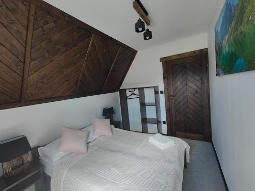 a bedroom with a bed with two pink pillows at Na polanie in Czerwienne