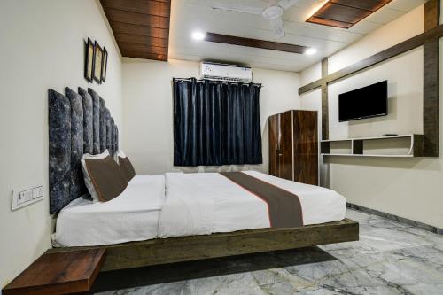 a bedroom with a bed and a tv on the wall at Hotel DR Green in Dewās