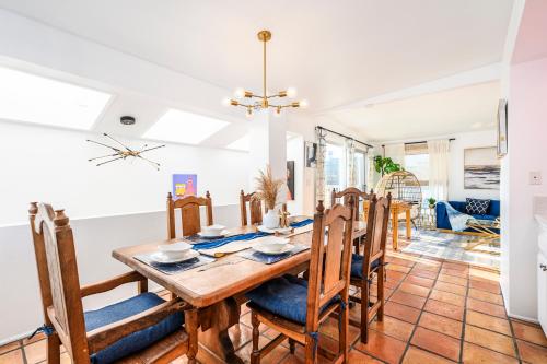 a dining room and living room with a wooden table and chairs at Beachside Luxury 4BR Arcade Fun Ocean Views in Manhattan Beach