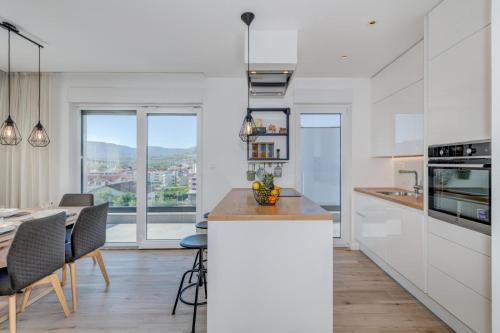 a kitchen with white cabinets and a table with chairs at Apartment Magdalena in Podstrana