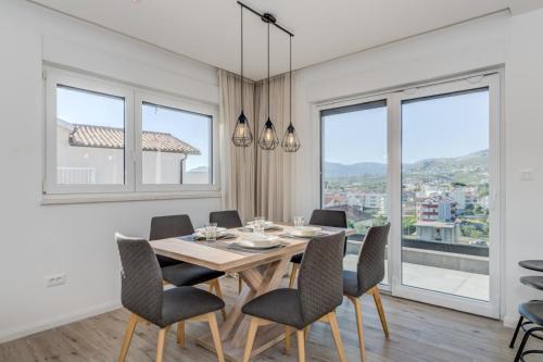 a dining room with a table and chairs and windows at Apartment Magdalena in Podstrana