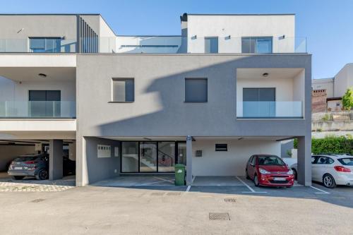 a building with two cars parked in a parking lot at Apartment Magdalena in Podstrana