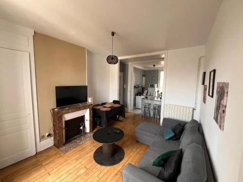 - un salon avec un canapé et une cheminée dans l'établissement Appartement de 2 chambres avec wifi a Limoges, à Limoges