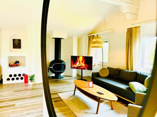 a living room with a couch and a fire place at Unique Penthouse with Gallery and Mountain View in Kandersteg