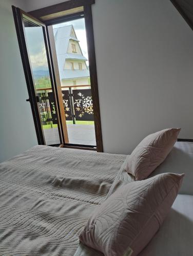 a bedroom with a bed with a large window at Na polanie in Czerwienne