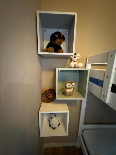 three shelves with stuffed animals on them on a wall at Antico Borgo - Appartamento in Cavriglia
