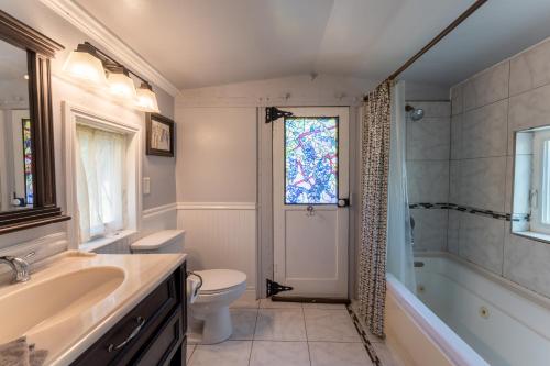 a bathroom with a sink and a toilet and a window at Little Red Caboose in Oakhurst