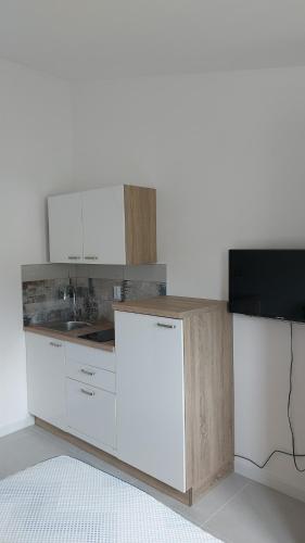a kitchen with white cabinets and a sink at Apartments LEON 1 in Rab