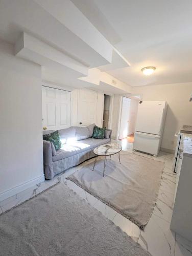 a living room with a couch and a refrigerator at Wonderland apartment - 6 min by walking in Vaughan
