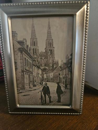 a framed picture of a street with a church at Le petit Conté - Maison calme en centre ville in Sées
