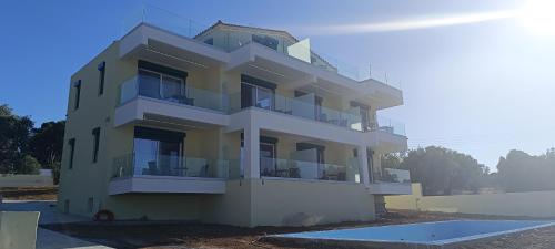 a white building with balconies on the side of it at AIR-IN Rooms with magnificent views in Artemida