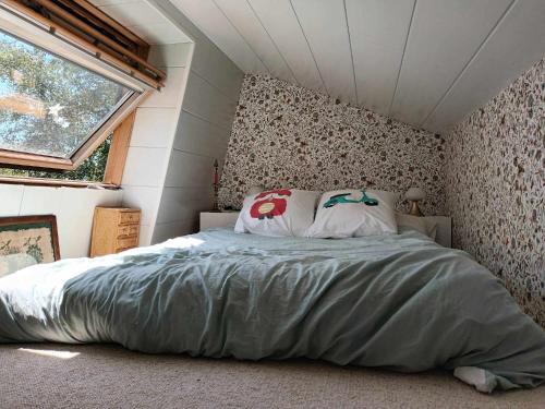 une chambre avec un lit dans une petite pièce dans l'établissement La maison bric et broc, à Saint-Carreuc