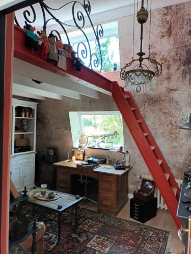 une cuisine avec un escalier rouge dans une pièce dans l'établissement La maison bric et broc, à Saint-Carreuc