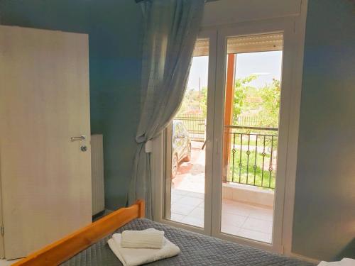 a bedroom with a bed and a door to a balcony at VILLA ARHONTIKO in Asprovalta