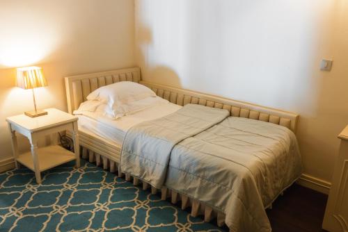 a small bedroom with a bed and a lamp on a table at Boutique Hotel Dobra Vila Bovec in Bovec