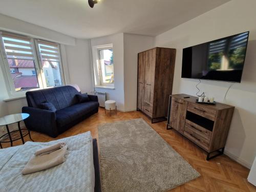 a living room with a couch and a tv at Little Wish in Gdańsk