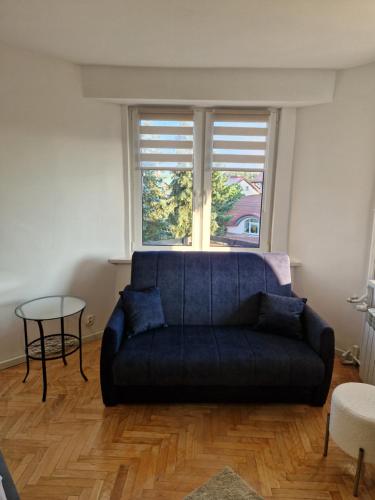 a blue couch in a living room with a window at Little Wish in Gdańsk