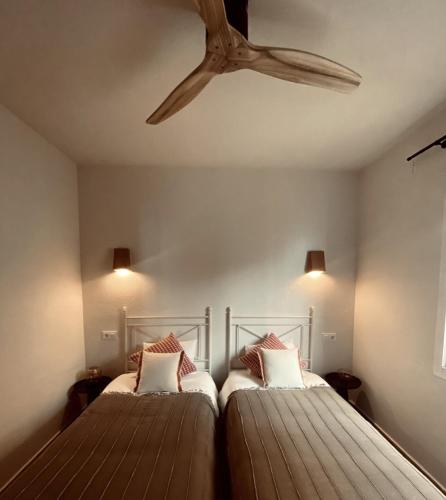 two beds in a room with a ceiling fan at Spectacular Panorama in Benitachell