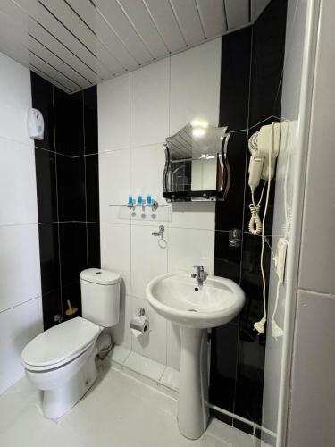 a white bathroom with a toilet and a sink at Hotel RichI G A in Tbilisi City