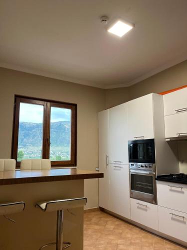 a kitchen with white cabinets and a window at Villa RESA - Intero allogio in Orikum