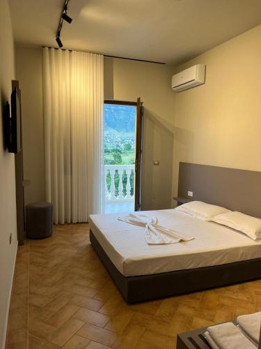 a bedroom with a large bed and a large window at Villa RESA - Intero allogio in Orikum