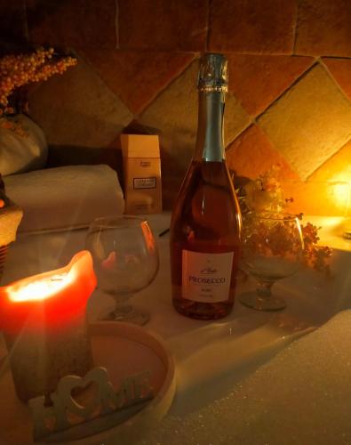 a bottle of wine and two glasses and a candle at Il Rifugio della Quiete in Scicli