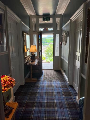 an empty hallway with aoyer with a door and a lamp at Ivybank Villa in Rothesay