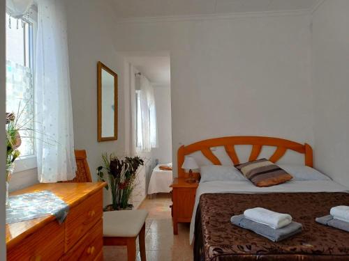 a bedroom with a bed and a dresser and a bed and a window at Villa de Lagos Coloridos in Los Montesinos