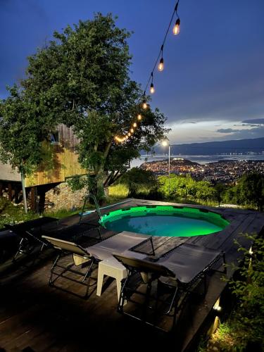 una piscina con 2 sillas y un árbol en Villa & Apartments Cityview Ohrid, en Ohrid