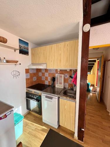 une cuisine avec un évier et une cuisinière four supérieur dans l'établissement Appartement bord de mer, au Barcarès