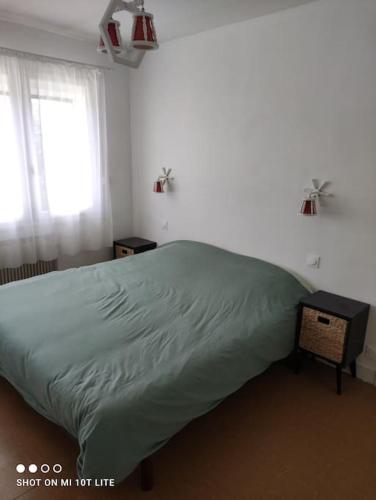 une chambre avec un lit vert et une fenêtre dans l'établissement Maison de vacances à 400m de la plage, à Berck-sur-Mer