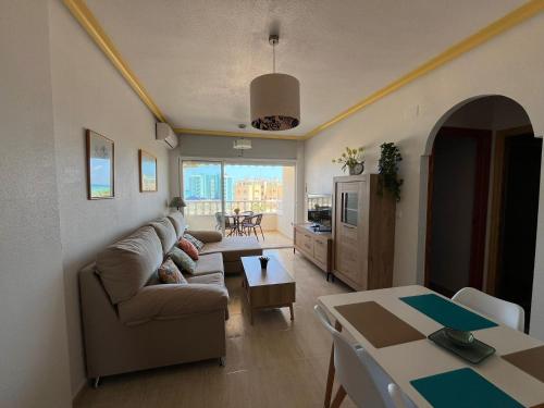 un soggiorno con divano e tavolo di Apartamento Vistamar-Relax a Guardamar del Segura