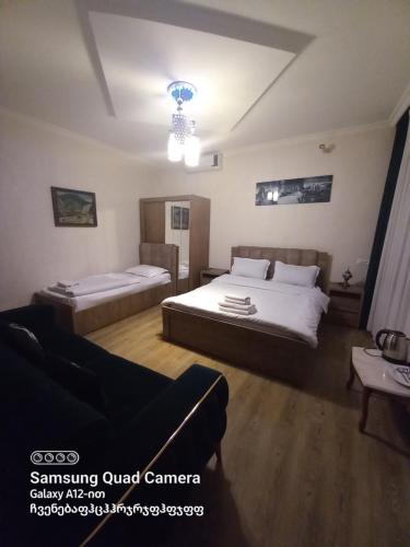 - une chambre avec 2 lits et un canapé dans l'établissement Hotel Zaira, à Tbilissi