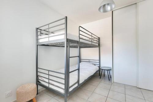 une chambre avec deux lits superposés et une table dans l'établissement Maisonnette à deux pas de la plage, à Andernos-les-Bains