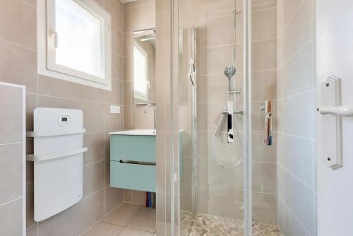 une salle de bain avec douche et lavabo dans l'établissement Maisonnette à deux pas de la plage, à Andernos-les-Bains