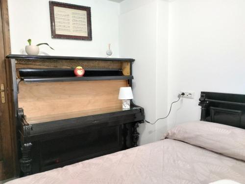 a bedroom with a bed and a black headboard at La camera nel villaggio in Messina