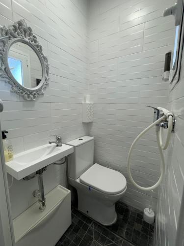a bathroom with a toilet and a sink and a mirror at Vistas al mar a 10 metros de la Playa de Regla PARKING GRATIS in Chipiona