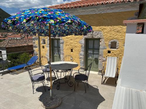 a table and chairs under an umbrella on a patio at Alexander House 2 in Leonidion