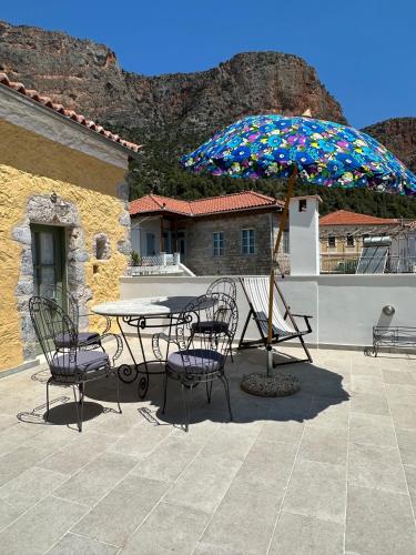 a patio with a table and chairs and an umbrella at Alexander House 2 in Leonidion