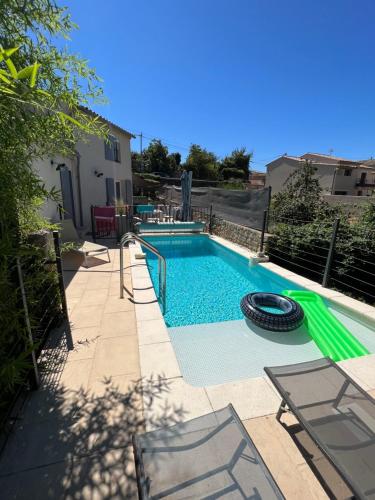 - une piscine avec un pneu à côté d'une maison dans l'établissement Villa Provence climatisée, jardin, piscine privée chauffée, Wifi, à Saint-Laurent-de-Carnols