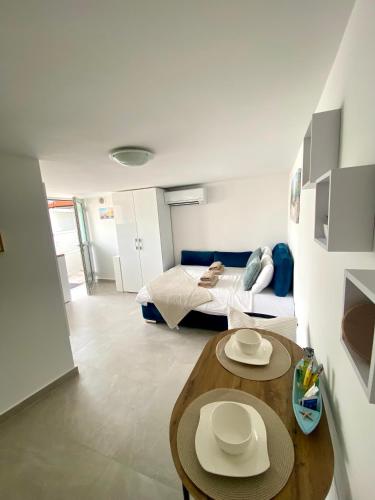 Un dormitorio con una cama y una mesa con dos sombreros encima. en Escape Studio, en Koper