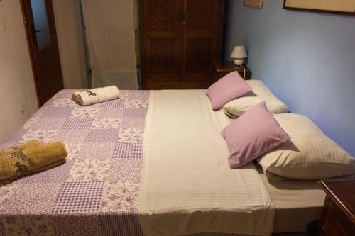 a bed with two pillows on top of it at Divna Apartments and Rooms in Račišće