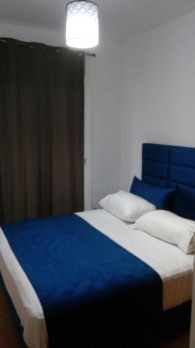 1 dormitorio con 1 cama grande y cabecero azul en Bab Sebta Fnideq en Fnidek
